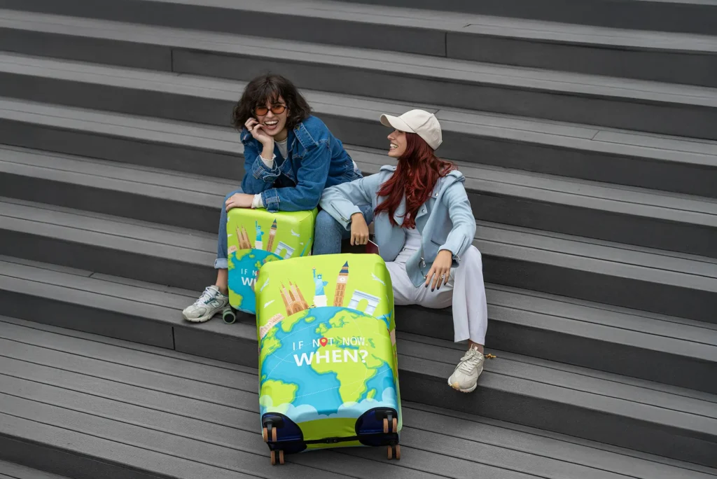 Početna 1 dve devojke sede na stepenicama zajedno sa putnim koferima koji nose zastitne navlake i gumene tockove iz obucikofer 1